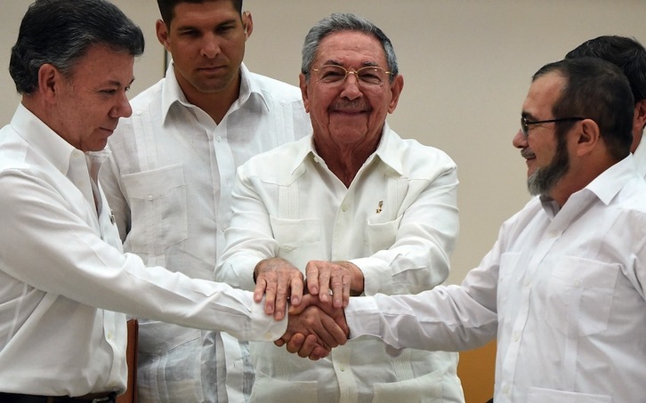 Juan Manuel Santos estrecha la mano del comandante en jefe de las FARC, Timoleón Jiménez ‘Timochenko’, con el auspiciador del diálogo, Raúl Castro. (Luis ACOSTA/AFP)