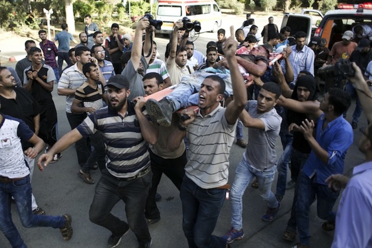 Palestinos trasladan el cuerpo de uno de los fallecidos. (SAID KHATIB  / AFP)