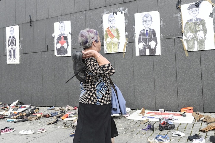 Una mujer lanza un zapato contra símbolos del Estado. (Idoia ZABALETA / ARGAZKI PRESS)