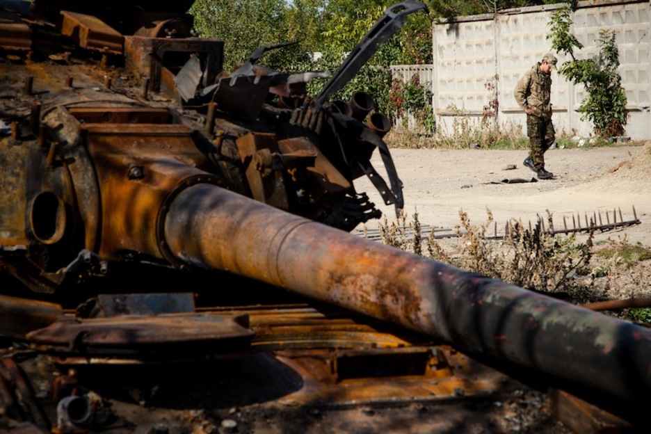 Un soldado ucraniano pasa ante un blindado quemado por un grad lanzado por el ejército rebelde cerca de Artemevsk. (Juan TEIXEIRA)