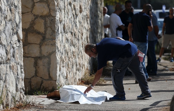 Un sanitario israelí cubre el cuerpo del adolescente palestino tiroteado en Jerusalén. (Ahmad GHARABLI/AFP) 