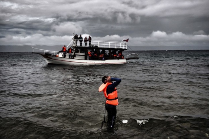 Un refugiado se lleva las manos a la cabeza tras llegar a isla griega de Lesbos. (Aris MESSINIS / AFP)