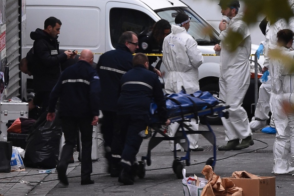 Policías sacan uno de los cadáveres de los dos fallecidos en el apartamento. (Eric FEFERBERG/AFP) 