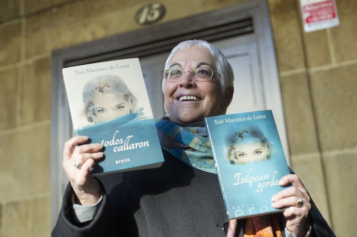 Toti Martínez de Lezea posa con sendos ejemplares de su nueva novela, en castellano y en euskara. (Jon URBE / ARGAZKI PRESS)