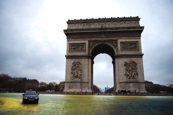Los activistas de Greenpeace han dibujado un sol amarillo alrededor del Arco del Triunfo. (Martin BUREAU/AFP) 
