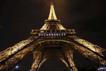 Mensaje en la Torre Eiffel de París contra el cambio climático. (Patrick KOVARIC / AFP)