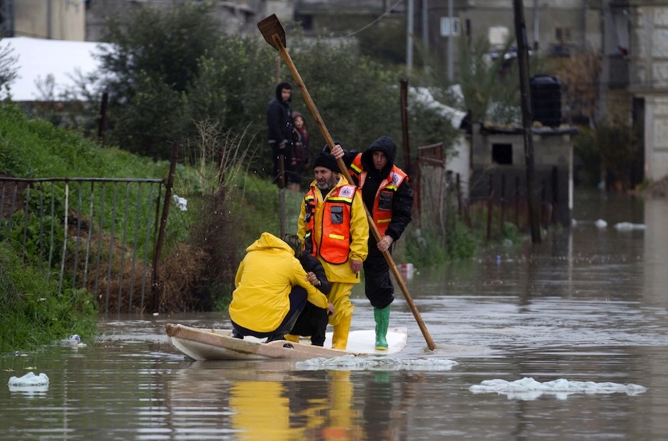 Los operarios han trabajado en barcas para limpiar las calles. (Mohammed ABED / AFP)
