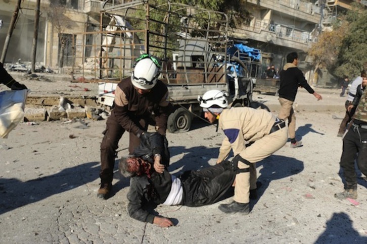 Dos miembros de los equipos de rescate asisten a un herido en Aleppo. (Ameer AL-HALBI/AFP)