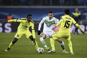 Draxler (Wolfsburgo), autor de un doblete, trata de zafarse de dos defensores del Gante. (JOHN THYS / AFP)