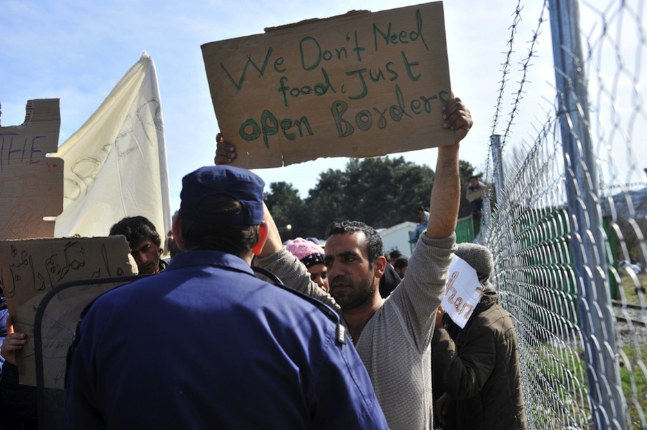 Un hombre porta un cartel reclamando la apertura de las fronteras. (SAKIS MITROLIDIS / AFP)
