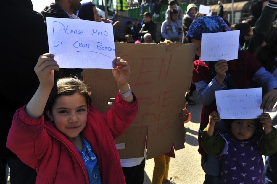 Niñas portan carteles pidiendo la apertura de las fronteras. (SAKIS MITROLIDIS / AFP)