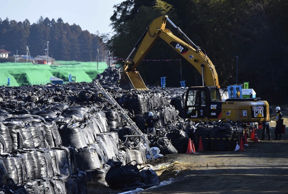 Una excavadora apila residuos en Tomioka, en la prefectura de Fukushima. (TORU YAMANAKA / AFP)