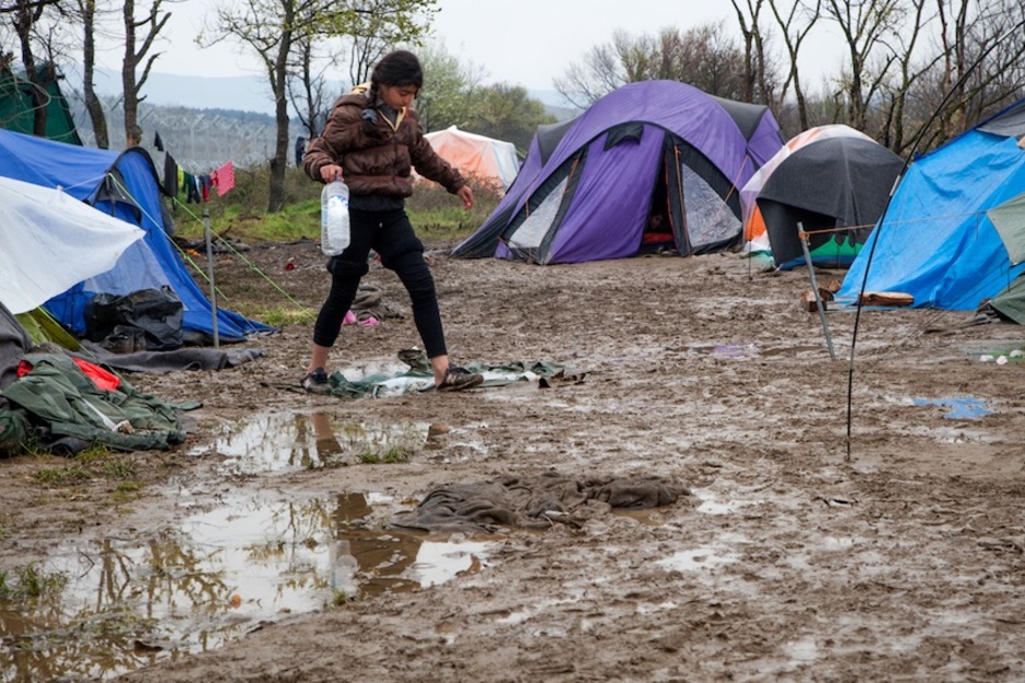 Una niña sale de su tienda en busca de agua potable. Una niña sale de su tienda en busca de agua potable.