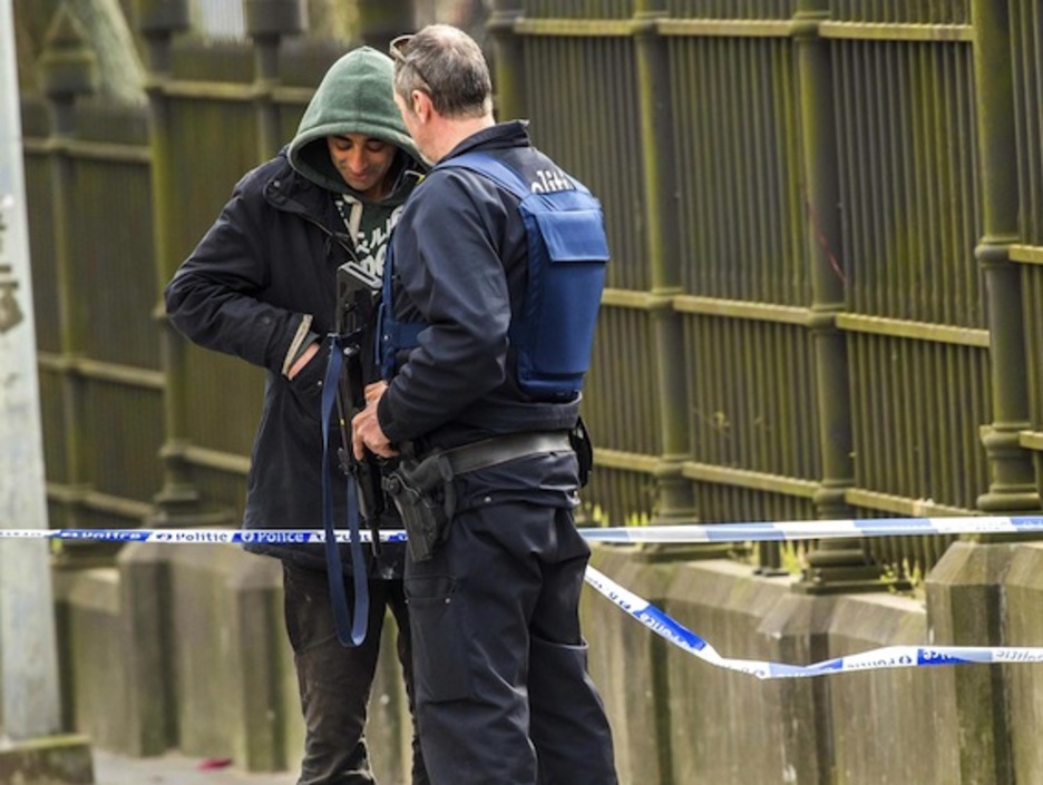 Un policía identifica a un viandante en la zona de la estación de Malbeek. (Philippe HUGUEN/AFP)