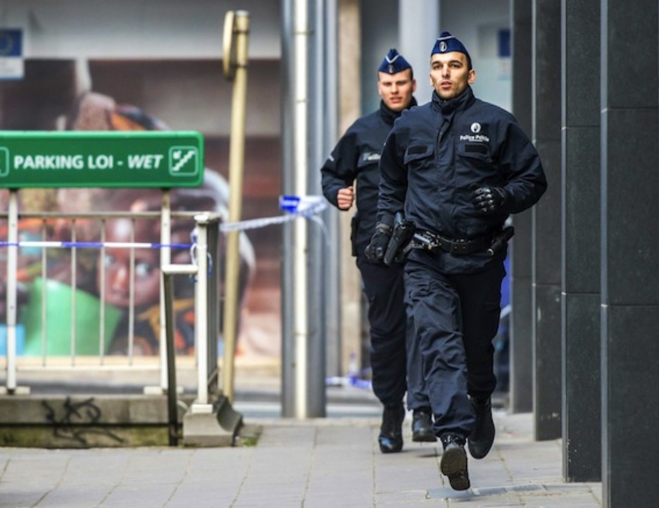 Dos agentes corren en las inmediaciones de Malbeek. (Philippe HUGUEN/AFP)