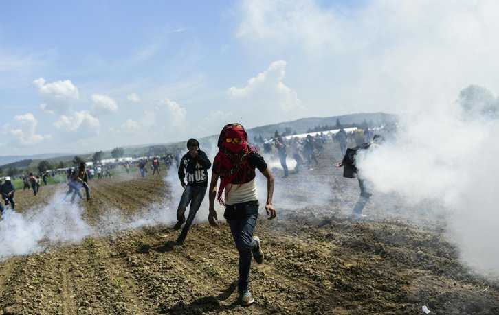 Migrantes corren tras las cargas policiales en Idomeni. (Bulent KILIC / AFP)