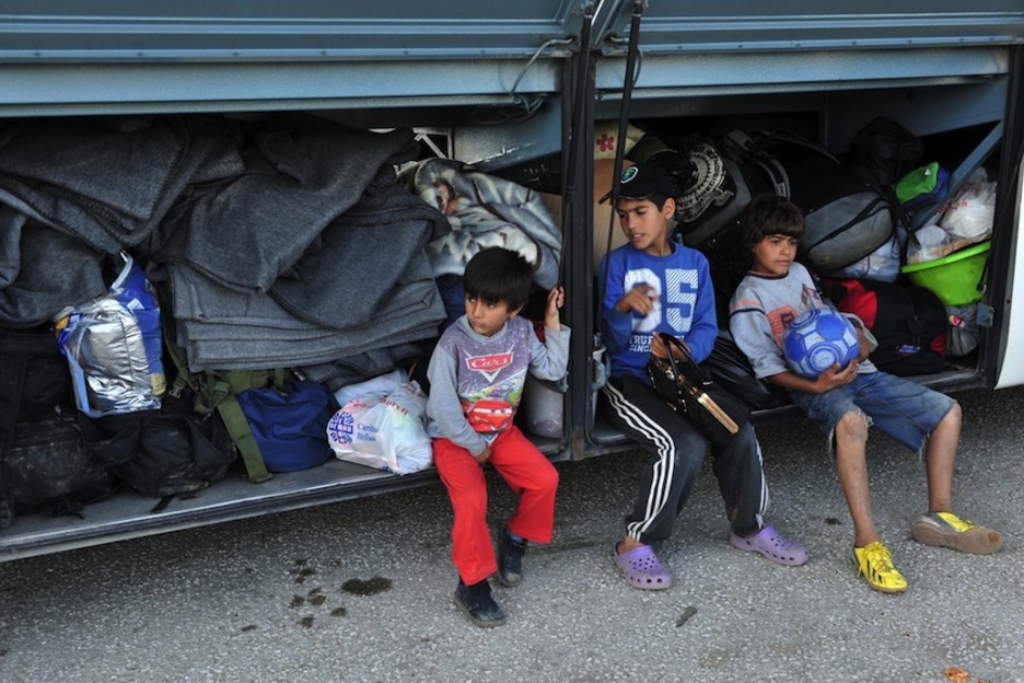 Los menores aguardan a subir al autobús. (Sakis MITROLIDIS / AFP)