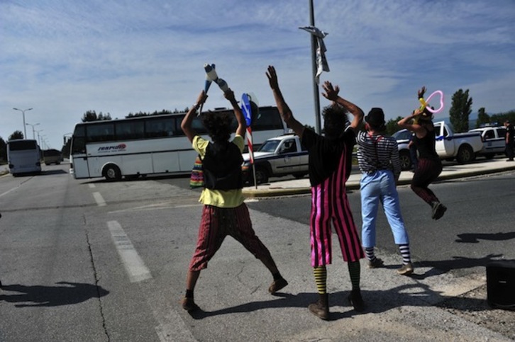 Un grupo de payasos solidarios, ayer, saludando a los refugiados desalojados de Idomeni. (Sakis MITROLIDIS/AFP)