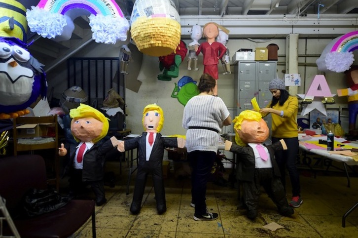 Dos mujeres fabrican piñatas de Trump para ser golpeadas por los niños. (FREDERIC J. BROWN / AFP)