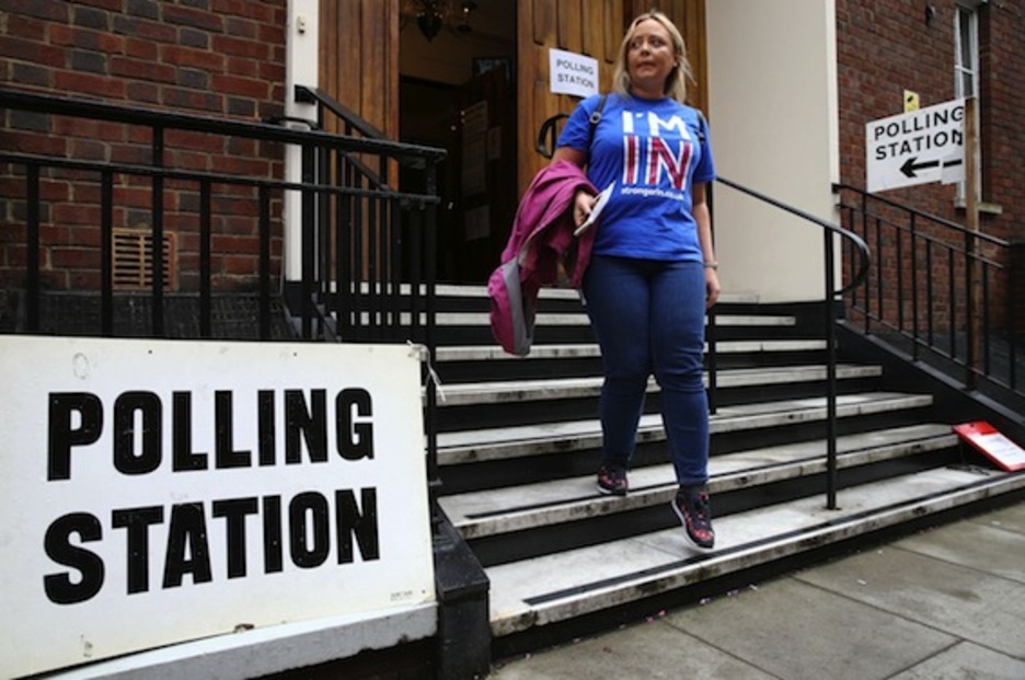 Una mujer sale de un colegio electoral con una camiseta en favor de la permanencia en la UE. (Justin TALLIS/AFP)