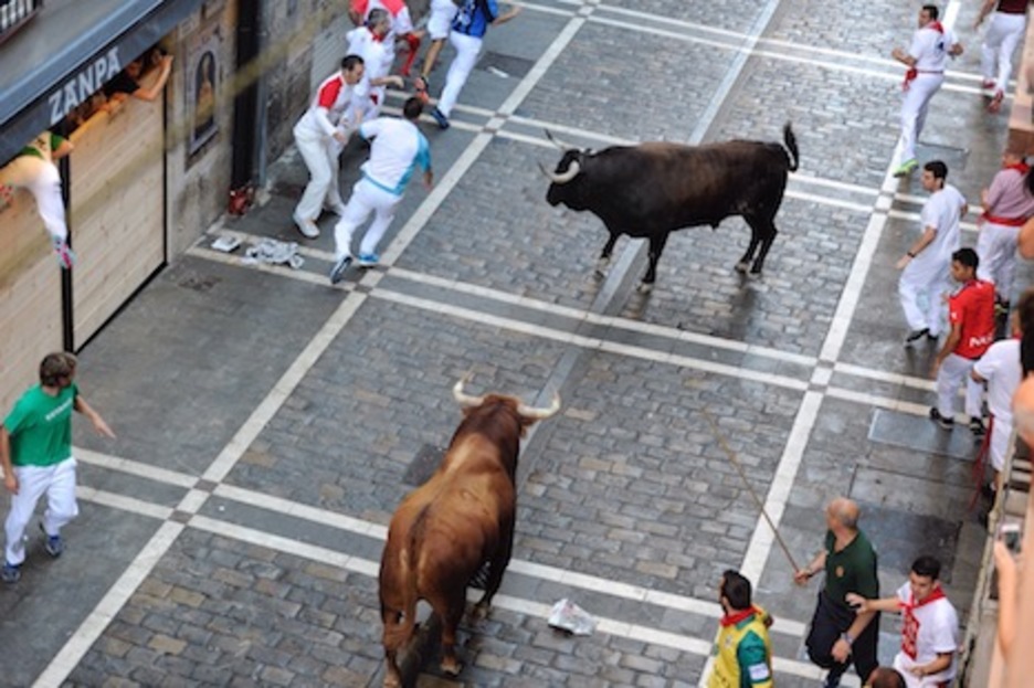 El último de los toros se aproxima a otro de los astados sueltos en Estafeta. (Jon URBE/ARGAZKI PRESS)