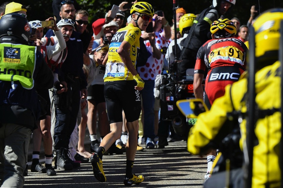 Froome ha salido corriendo a pie tras chocar con una moto y romper la bici. (Jeff PACHOUD / AFP)