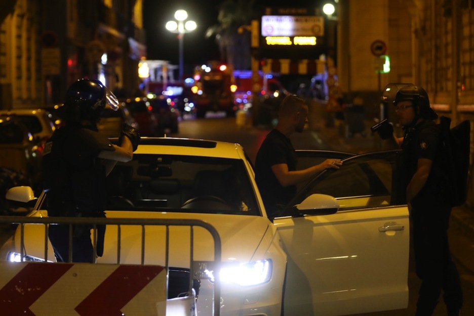 Dos policías apuntan con sus pistolas al conductor de un coche. (VALERY HACHE / AFP)