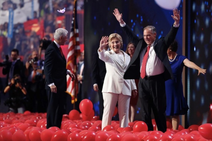 Hillary Clinton saluda junto a su candidato a vicepresidente, Tim Kaine. (Aarno P. BERSTEIN / AFP)