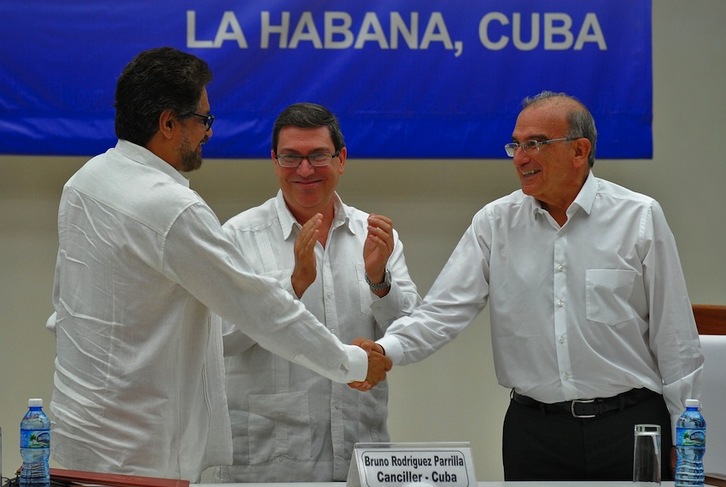 Humberto de la Calle e Iván Márquez se estrechan la mano tras firmar el Acuerdo Final en La Habana. (Yamil LAGE/AFP)