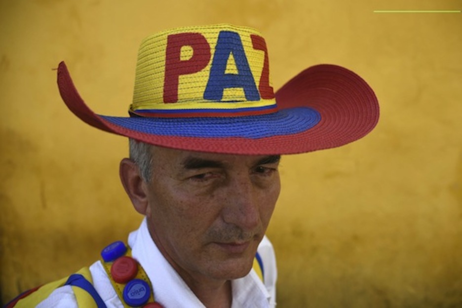 Un hombre viste un sombrero con un mensaje en favor de la paz. (Luis ROBAYO/AFP)