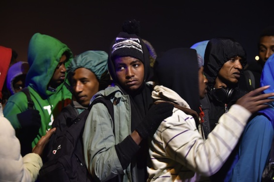 Personas que permanecían acampadas en Calais se agolpan en el proceso de desalojo. (Philippe HUGUEN/AFP)
