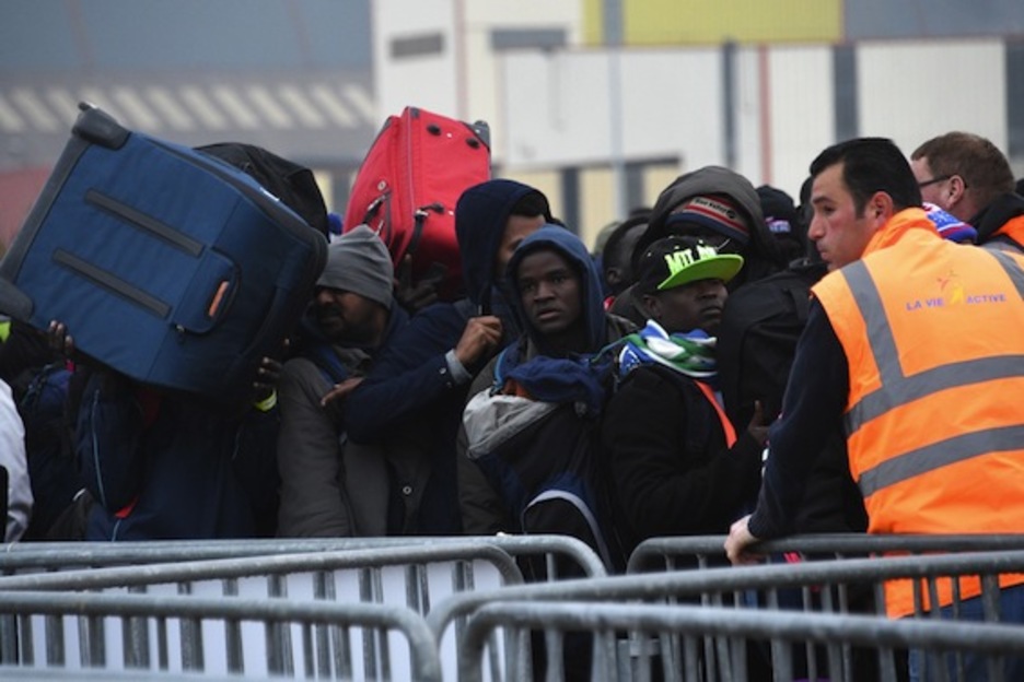 Migrantes y refugiados aguardan con sus pertenencias a cuestas. (Denis CHARLET/AFP)