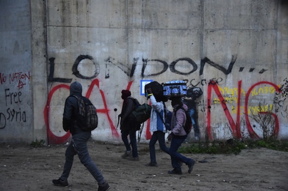 Varias personas pasan ante un muro en el que se lee «London calling». (Philippe HUGUEN/AFP)