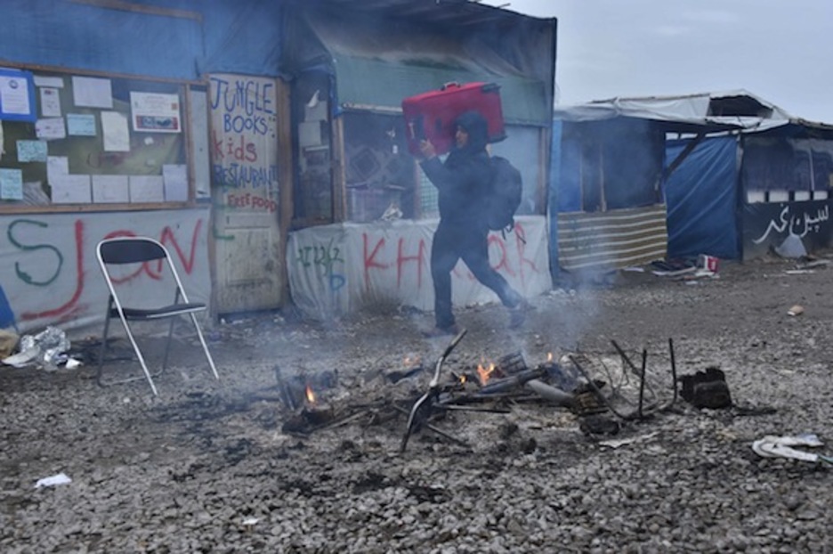 Un hombre camina con su equipaje a cuestas por la «jungla» de Calais. (Philippe HUGUEN/AFP)