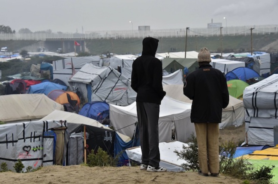 Dos hombres miran miran a la «jungla» de Calais. (Philippe HUGUEN/AFP)