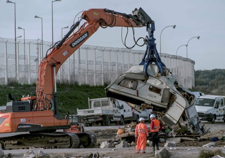 Una grúa levanta una caravana en las tareas de desmantelamiento de La Jungla. (PHILIPPE HUGUEN / AFP)