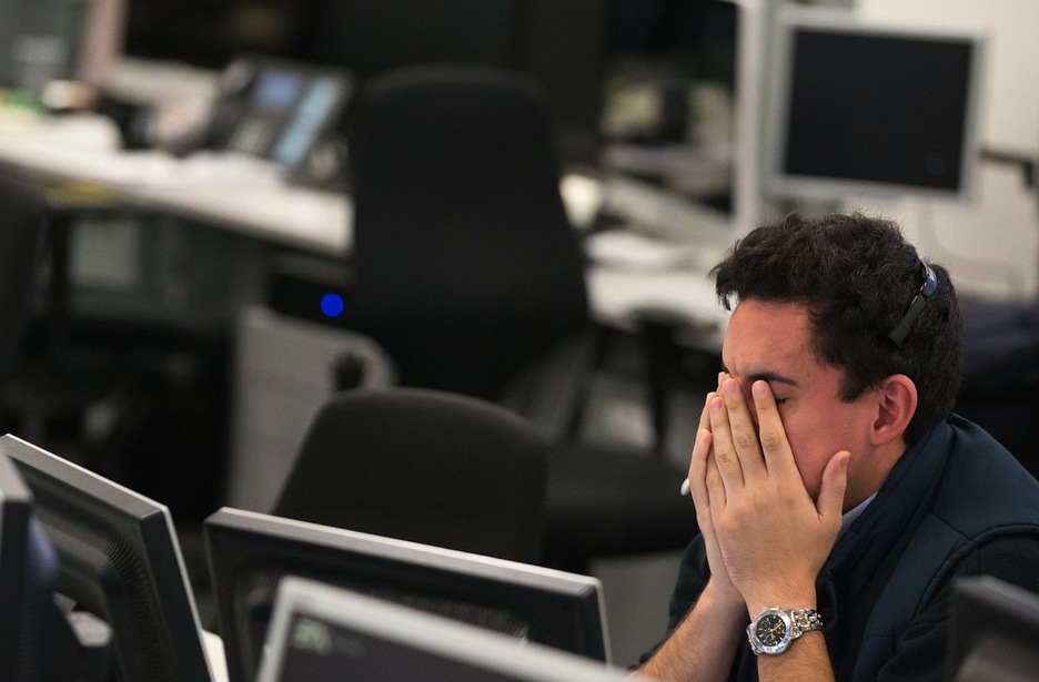 Un corredor de la Bolsa londinense reacciona tras el desplome de los mercados por la victoria de Trump. (Daniel LEAL-OLIVAS/AFP)