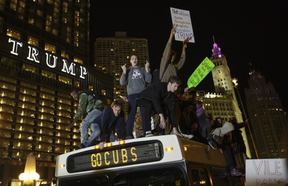 Manifestantes protestan sobre un autobús al lado de la torre Trump de Chicago. (John GRESS/AFP)