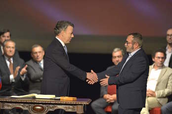 El presidente Santos y el líder de las FARC se dan la mano tras firmar el nuevo acuerdo. (Luis ROBAYO / ARGAZKI PRESS)