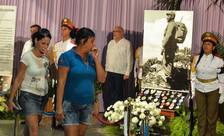 Dos mujeres pasan ante uno de los puntos de los lugares instalados para rendir homenaje a Fidel Castro. (Adalberto ROQUE / AFP)