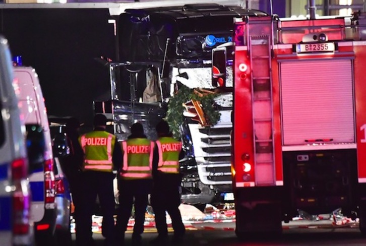 Varios policías observan el camión que arrolló a los visitantes del mercado navideño de Berlín. (John MACDOUGALL/AFP)