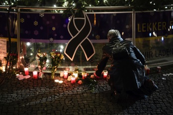 Una mujer coloca una vela en Berlín. (Clemens BILAN / AFP)