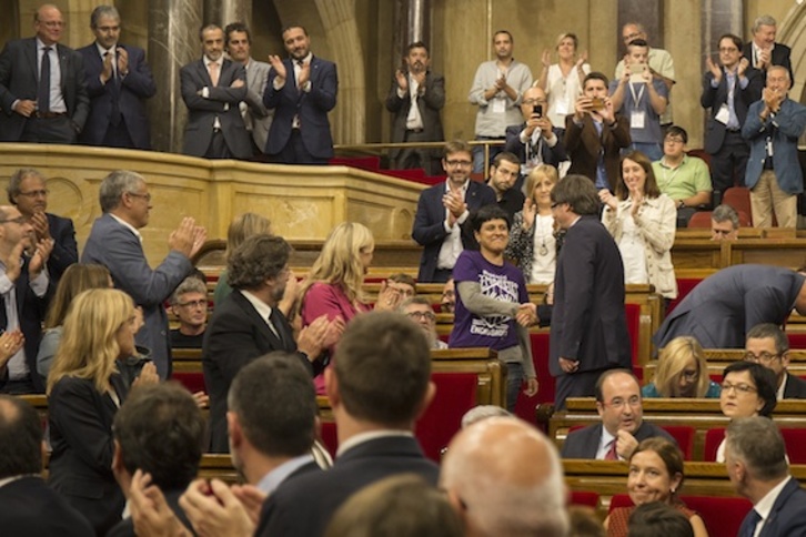 El president, Carles Puigdemont, y Anna Gabriel (CUP) se dan la mano en un pleno. (PARLAMENT)