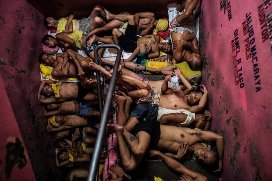 Presos intentando dormir en las escaleras en una hacinada prisión en Manila. (Noel CELIS/AFP)