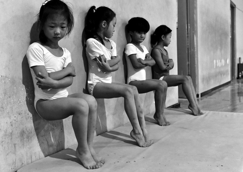 Cuatro estudiantes de una escuela de gimnasia en Xuzhou, China, hacen entrenamiento de presión de pies. (Tiejun WANG)