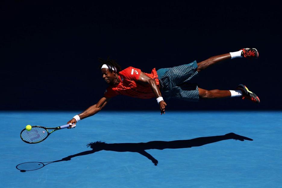 El tenista Gaël Monfils «vuela» en un golpe de derecha durante el Abierto de Australia de 2016. (Cameron SPENCER)