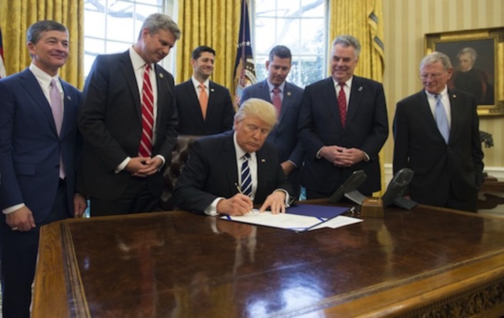 El presidente de EEUU, Donald Trump, firma un decreto en su despacho. (Saul LOEB/AFP)