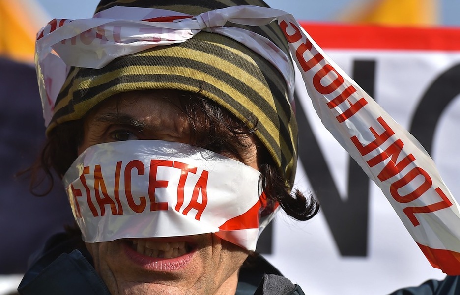 Manifestariak CETAren aurka mozorrotu dira. (Patrick HERTZOG / AFP)
