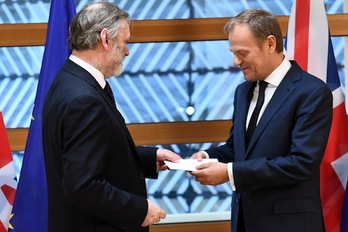 El presidente del Consejo Europeo, Donald Tusk, recibe de manos del embajador británico ante la UE, Tim Barrow, la invocación del artículo 50 del Tratado de Lisboa remitido por Theresa May. (Emmanuel DUNAND/AFP)