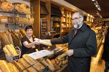 El consejero Domínguez compra una barra de pan con el envoltorio impreso con el mensaje de la campaña. (GOBIERNO DE NAFARROA)